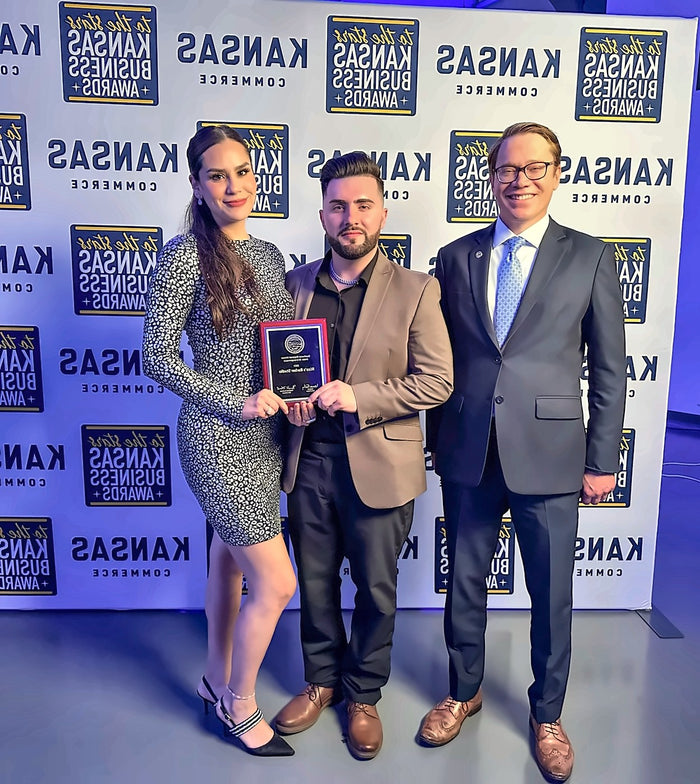 Osvaldo Rizo holding the Kansas Business Awards 2023 plaque